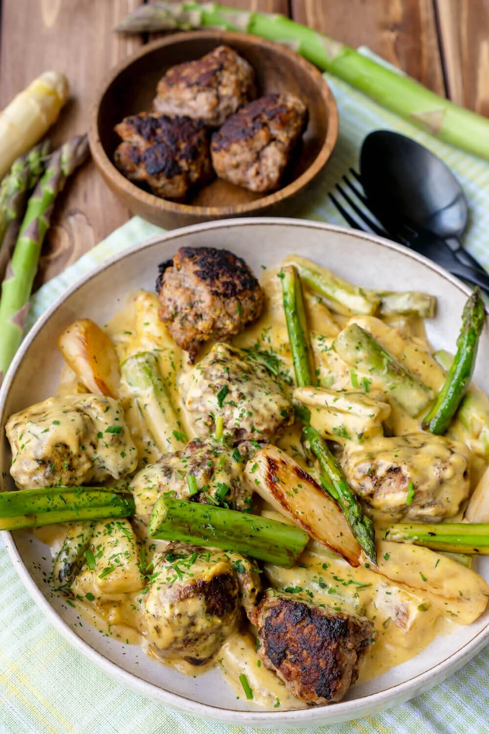 Asparagus pan with meatballs and sauce hollandaise on the plate