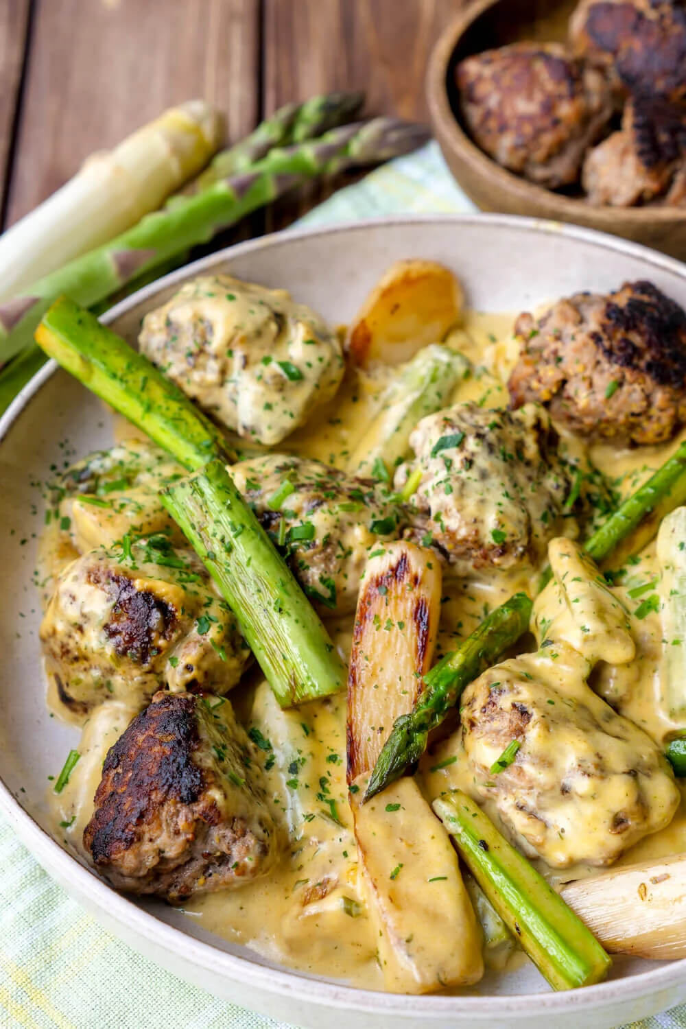 Asparagus pan with meatballs and sauce hollandaise on the plate