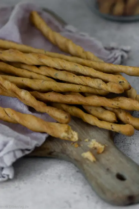 Grissini bake with herbs and parmesan. This recipe is easy and quick to make and perfect as a snack on New Year's Eve or other parties and celebrations.