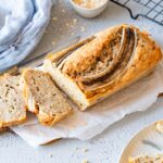 Banana bread without egg on a cutting board, two pieces have already been cut.