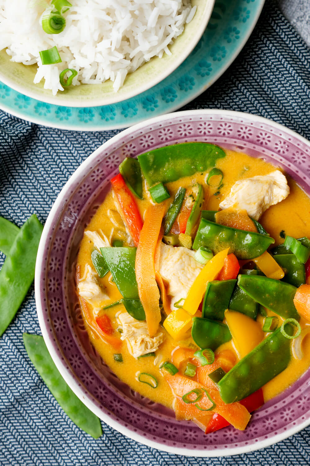 Red Thai curry with chicken, sugar pods, peppers and carrots in the bowl