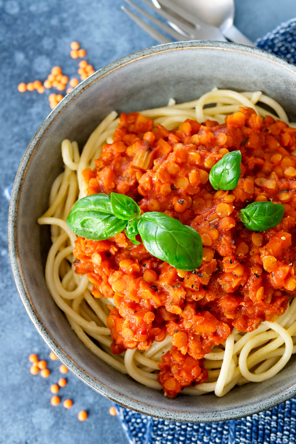 Spaghetti with red lens bolognese and basil in the bowl