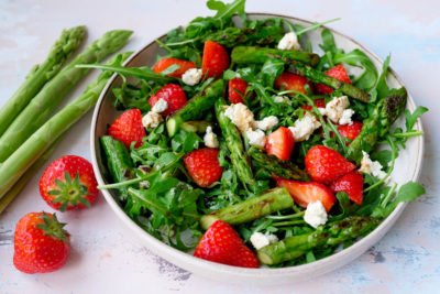 Fruity salad with green asparagus, strawberries, arugula and feta