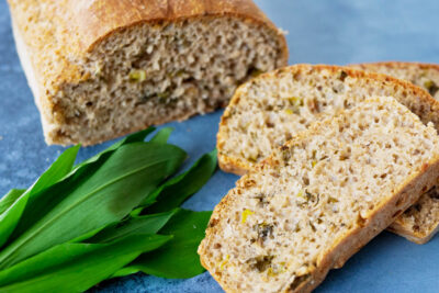 Cut off wild garlic bread on the blue surface