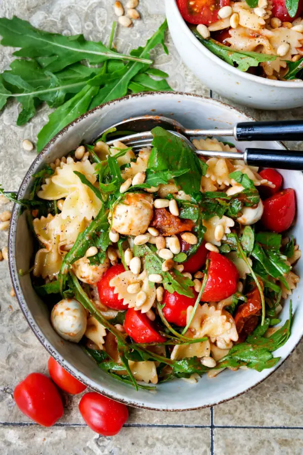 Aromatic Italian pasta salad with tomatoes, rocket, pine nuts and mozzarella