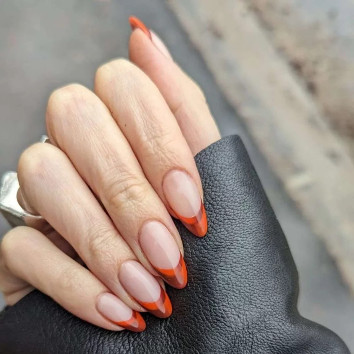 These elegant tips in orange are immediately noticeable at the French Nails