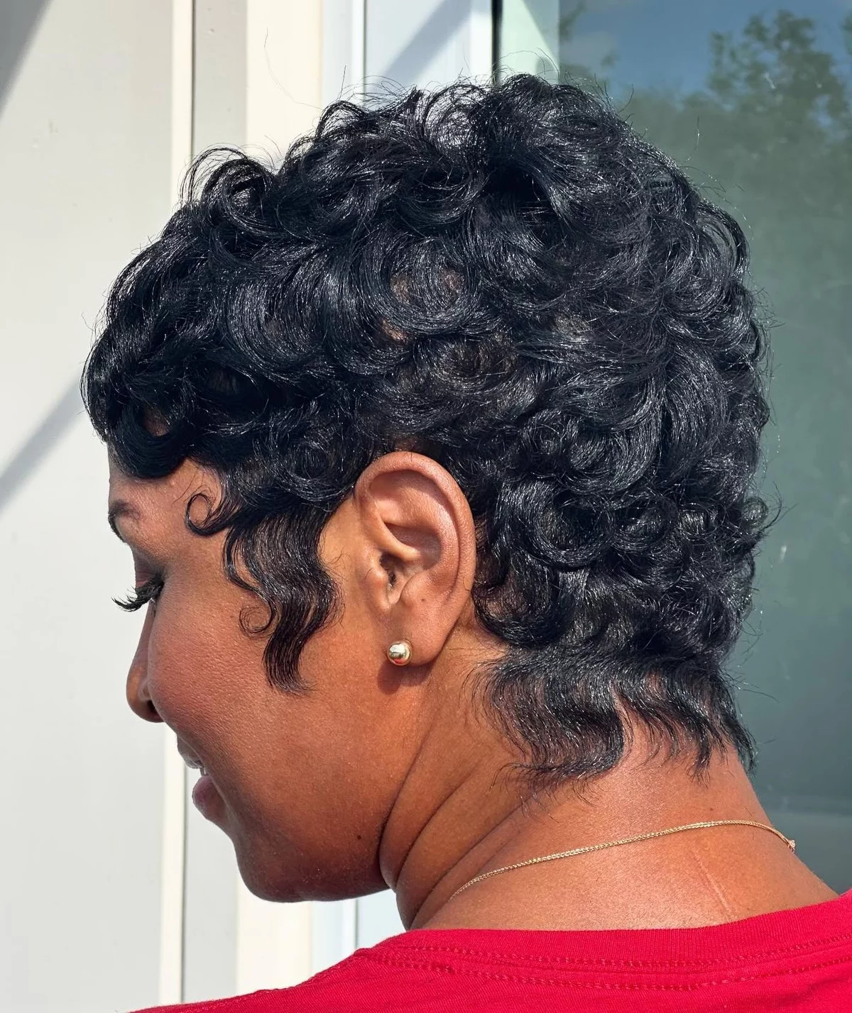 Woman wears pixie and has black curly hair