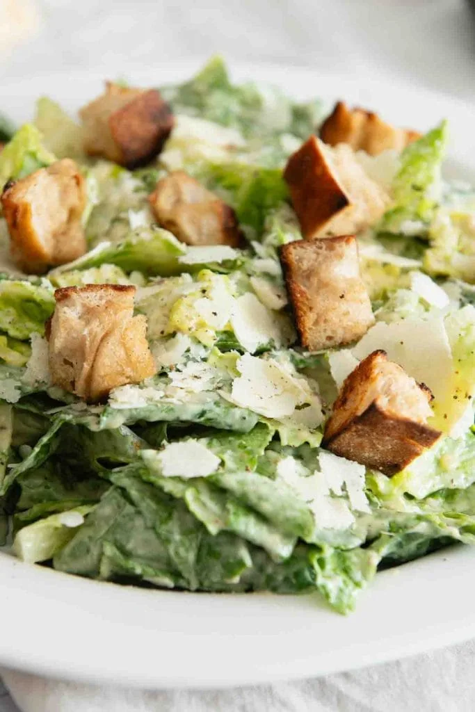 Original Caesar Salad Recipe: Roman salad in a creamy dressing, garnished with large croutons, planed parmesan and black pepper