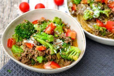 Noodles with minced meat, broccoli and tomatoes in the bowl