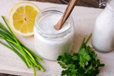 Ranch dressing in a screw-top glass with a wooden spoon.
