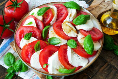 Tomate mozzarella with basil on a plate.
